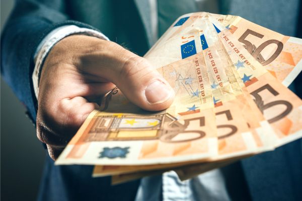 Businessman from bank offering money loan in euro banknotes, selective focus.